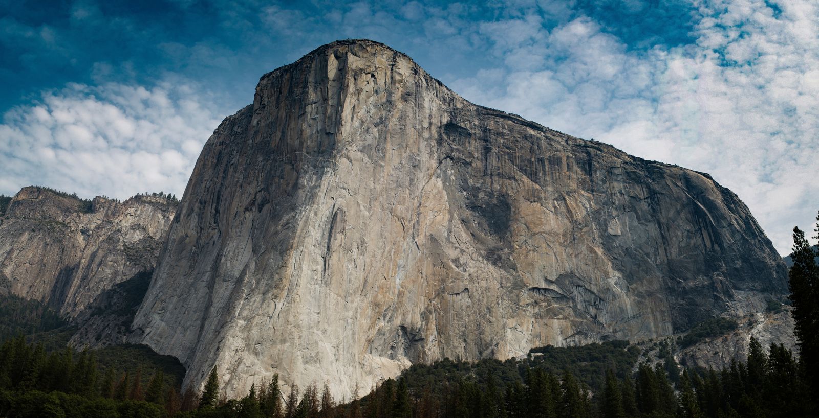The sheer granite face of El Capitan under a cloudy sky